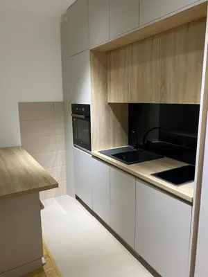 a kitchen with white cabinets and a stove top oven at Stylish charming apartment in Podgorica