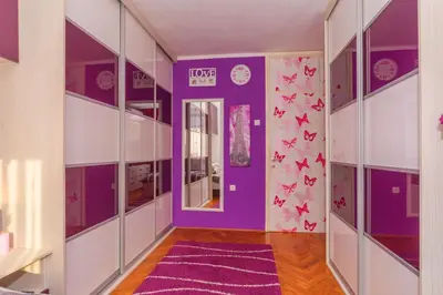 a purple hallway with a mirror and a purple wall at Beni Apartment in Bar