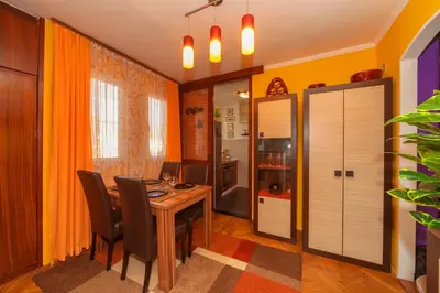 a dining room with a wooden table and chairs at Beni Apartment in Bar