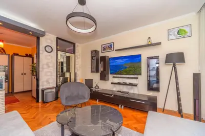 a living room with a table and a tv at Beni Apartment in Bar