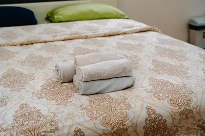 a pile of towels sitting on top of a bed at Stex Urban 1 in Podgorica