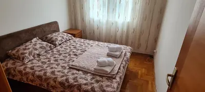 a bedroom with a bed with towels on it at Apartman Velimir Stari Aerodrom in Svijetin Brijeg