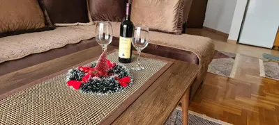 a table with two glasses and a bottle of wine at Apartman Velimir Stari Aerodrom in Svijetin Brijeg