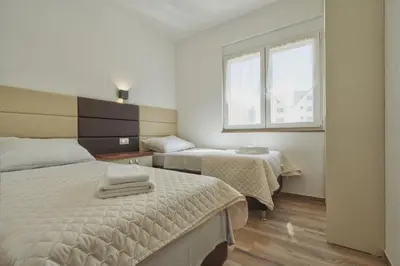 a hotel room with two beds and a window at El Pasaja in Dobra Voda