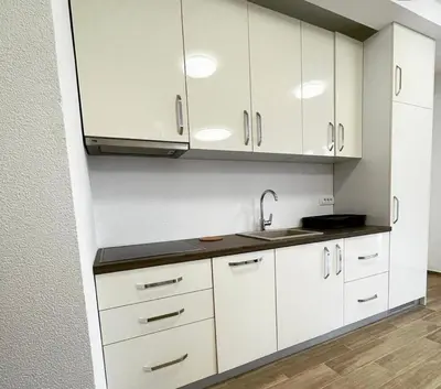 a kitchen with white cabinets and a sink at El Pasaja in Dobra Voda