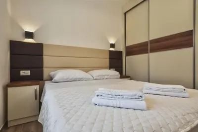 a bedroom with a white bed with towels on it at El Pasaja in Dobra Voda