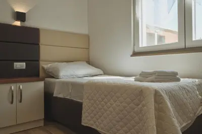 a small bedroom with a bed and a window at El Pasaja in Dobra Voda