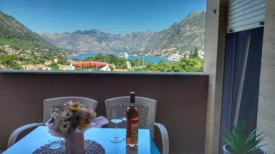 a table with a vase of flowers on a balcony at Sea view apartment in Kotor ! Apartment Popica in Kotor