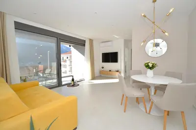 a living room with a yellow couch and a table at Solaris Lux Apartments in Kotor