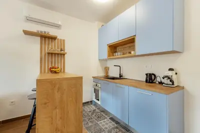 a kitchen with blue cabinets and a counter top at LANA Sea View Apartment in Kotor