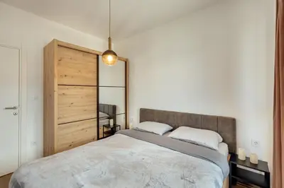 a bedroom with a large bed and a mirror at LANA Sea View Apartment in Kotor