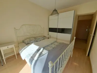 a bedroom with a white bed in a room at Delta apartment City kvart in Podgorica