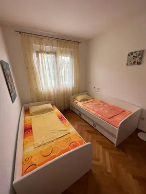 two twin beds in a room with a window at Vanilla Apartment Petrovac in Petrovac na Moru