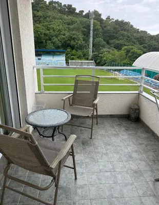 a balcony with chairs and a table and a baseball field at Vanilla Apartment Petrovac in Petrovac na Moru