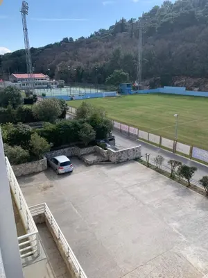 a car parked in a parking lot next to a field at Vanilla Apartment Petrovac in Petrovac na Moru