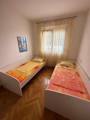 two beds in a room with wooden floors at Vanilla Apartment Petrovac in Petrovac na Moru