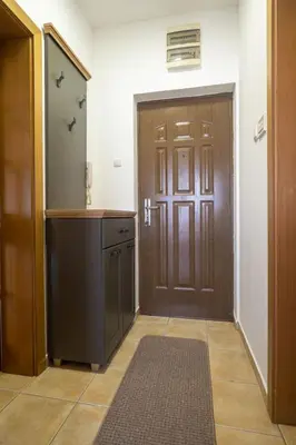 a hallway with a door and a counter and a kitchen at Norandvik Apartment in Podgorica