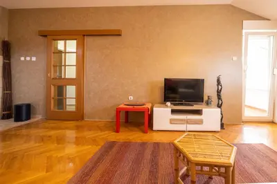 a living room with a television and a red table at Norandvik Apartment in Podgorica