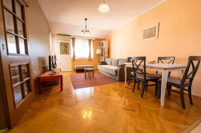 a living room with a table and a couch at Norandvik Apartment in Podgorica