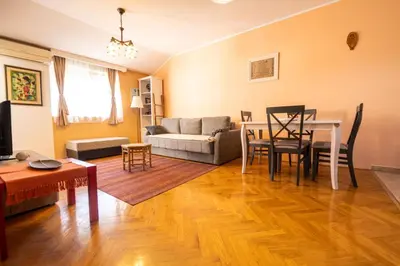 a living room with a table and a couch at Norandvik Apartment in Podgorica