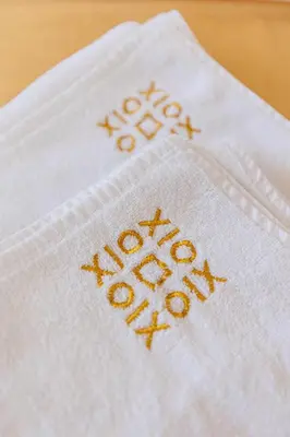a white napkin with gold embroidery on it at XIO Apartments in Bar