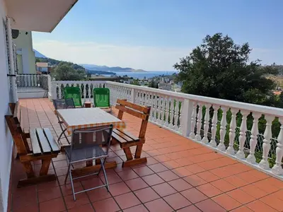 a patio with tables and chairs on a balcony at Villa Peonia in Sutomore