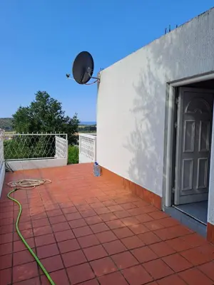 a patio with a door and a green hose at Villa Peonia in Sutomore