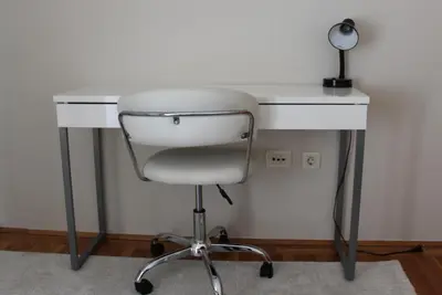 a white desk with a chair and a lamp at Honey Home in Podgorica