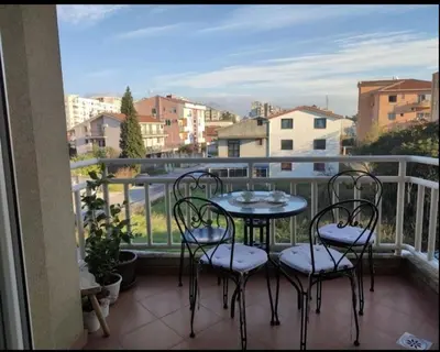 a table and four chairs on a balcony with a view at Honey Home in Podgorica