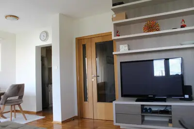 a living room with a flat screen tv on a entertainment center at Honey Home in Podgorica