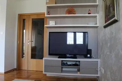 a flat screen tv in a living room at Honey Home in Podgorica