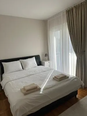 a bedroom with a large bed with two towels on it at Honey Home in Podgorica
