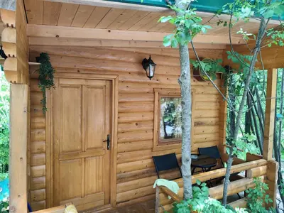 a wooden cabin with two chairs and a door at Still cabin in Cetinje