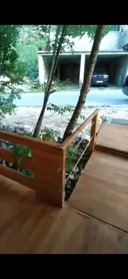 a wooden bed in a room with a tree at Still cabin in Cetinje