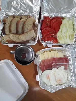 a table topped with trays of different types of food at Still cabin in Cetinje