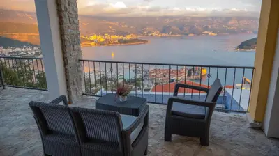a balcony with chairs and a table and a view of the water at Viewpoint Villa in Budva