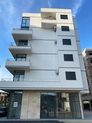 a tall white building with windows on it at Crown Apartment in Ulcinj