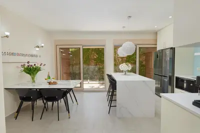 a kitchen with a white counter and a table and chairs at Huge Apartment with Stunning View and Sauna in Kotor