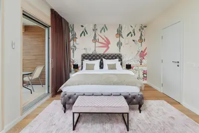 a bedroom with a large bed and a table at Huge Apartment with Stunning View and Sauna in Kotor