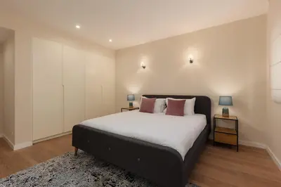 a bedroom with a large bed with white walls at Huge Apartment with Stunning View and Sauna in Kotor