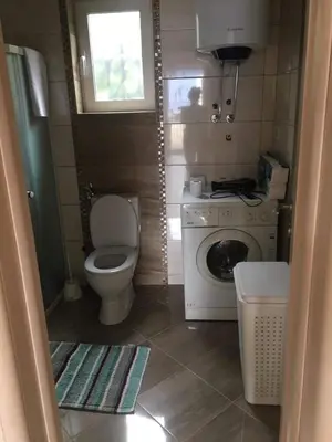 a small bathroom with a toilet and a washing machine at Apartments Relax in Utjeha