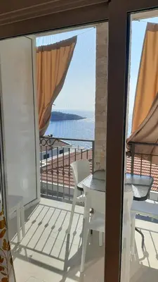 a balcony with a table and chairs and a view of the ocean at Apartments Relax in Utjeha
