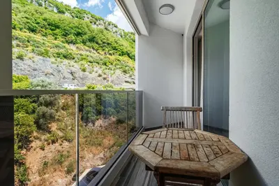 a balcony with a wooden bench and a window at Aura Tower Aparments by In Property in Rafailovici