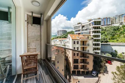 a balcony with a chair and a view of buildings at Aura Tower Aparments by In Property in Rafailovici