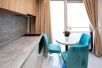 a kitchen with blue chairs and a small table at Aura Tower Aparments by In Property in Rafailovici