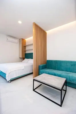 a bedroom with a couch and a bed and a table at Aura Tower Aparments by In Property in Rafailovici