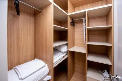 a walk in closet with wooden walls and shelves at Aura Tower Aparments by In Property in Rafailovici