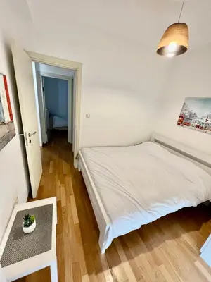 a bedroom with a white bed and a table at City Centre Getaway in Budva
