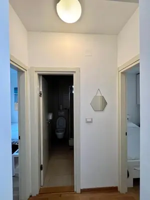 a bathroom with a toilet and a light on the wall at City Centre Getaway in Budva
