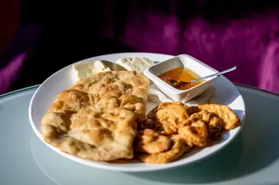 a plate of food with bread and a bowl of dipping sauce at Motel Celebic in Podgorica